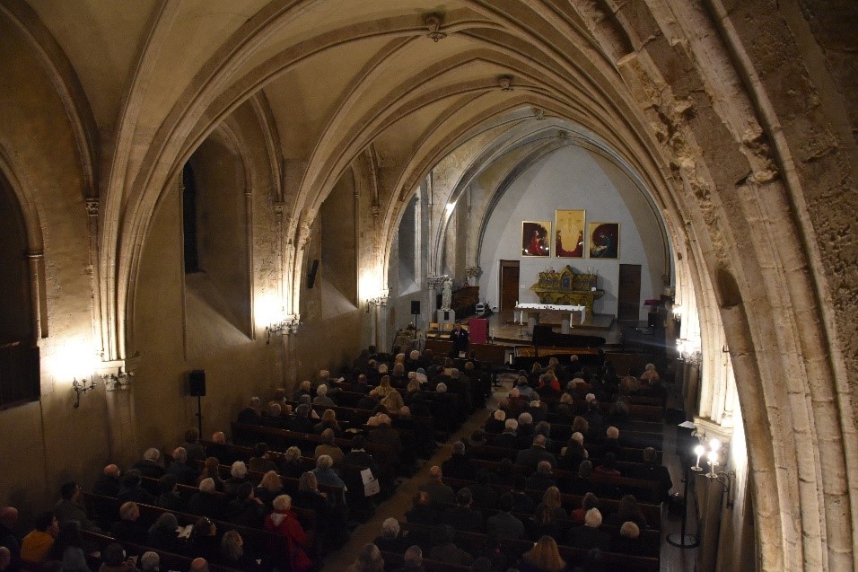 Photo du public assis dans la chapelle du lycée Henri IV, prise en contre plongée de la tribune de l’orgue.
