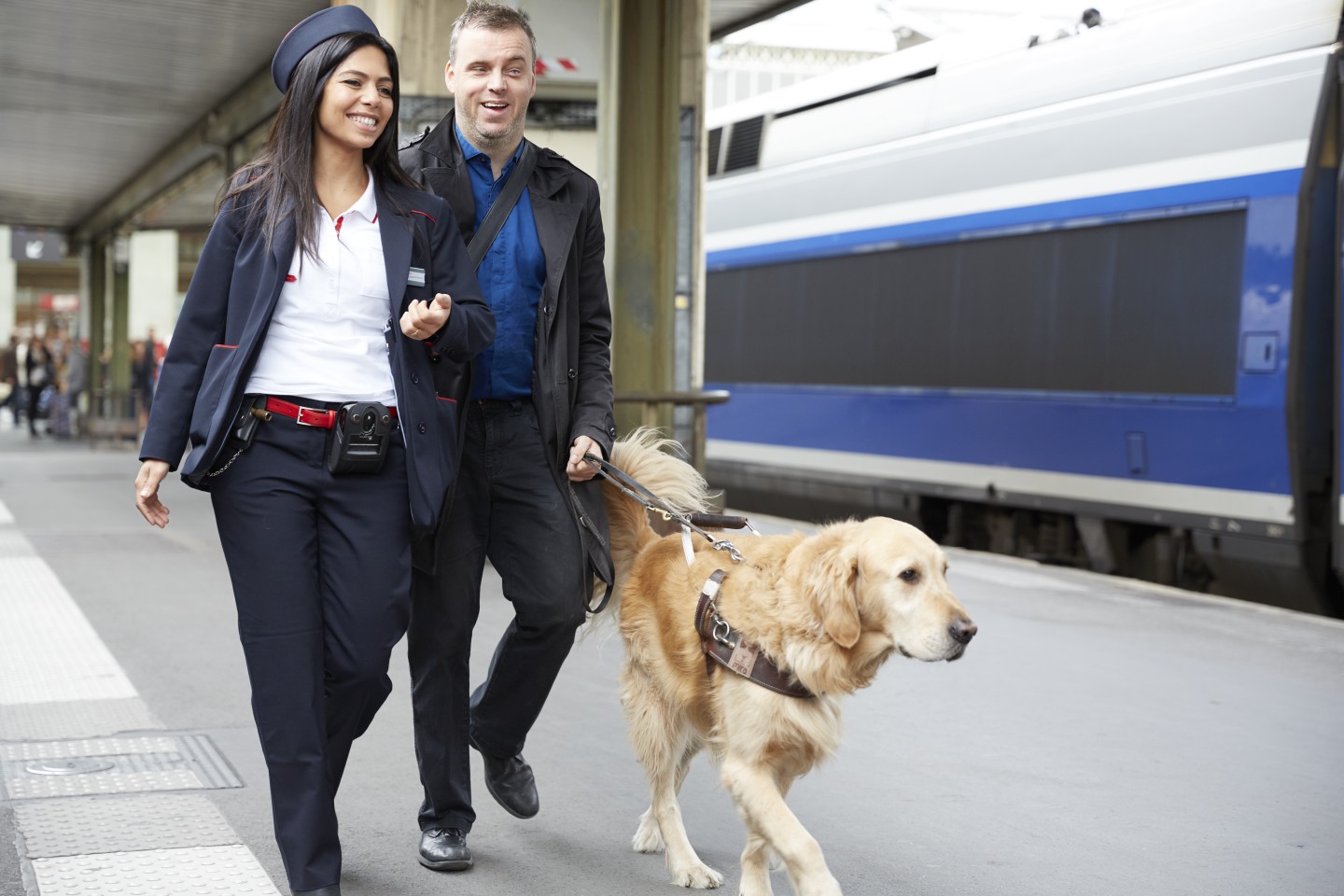 Un membre du personnel SNCF accompagne une personne aveugle à son train