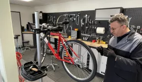 Photo d'un salarié déficient visuel réparant un vélo.