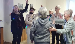 Plusieurs personnes dansent autour d'une chanteuse