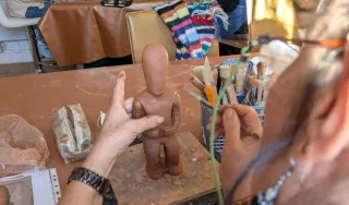 Au premier plan une statuette en cours de fabrication