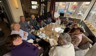Plusieurs personnes autour d'une table dans un café.