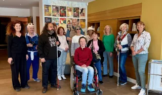 Plusieurs personnes dont une en fauteuil roulant dans le hall d'accueil d'un musée