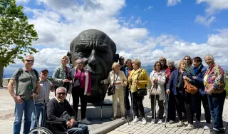 Plusieurs personnes prennent la pose autour d'une statue de plus de 2 mètres de haut représentant la tête de Picasso 