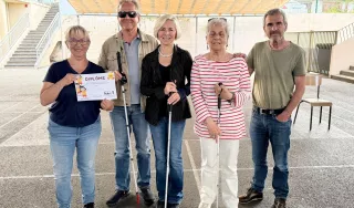 Cinq personnes posent fièrement en mettant en avant un diplôme