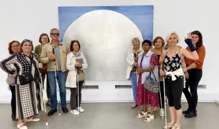 Deux groupes de visiteurs prennent la pose photo autour d'une œuvre d'art