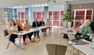 Des personnes autour de deux tables pendant une réunion de travail