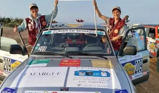 Debout à chaque portière avant Laure et Harmony présentent le drapeau association Valentin Haüy au dessus du pare-brise du quatre-quatre