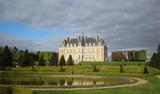 Photo de la façade du château de Sceaux avec au premier plan le parc avec un jardin à la Française.