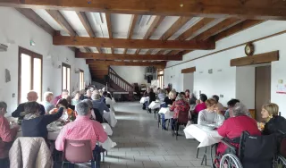 Une vision globale des participants à l'assemblée assis à leurs tables pour la prise du repas.