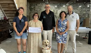 De gauche à droite on peut voir sur la photo Nathalie, l'éducatrice de violette, Geneviève Tailleur tenant le fac-similé du chèque. A sa droite M. Saves, président de l'association Chiens Guides Grand Sud Ouest et M et Mme Fay la famille d'accueille de Violette. Et aux pieds de sa maitresse la vedette du jour Violette. 