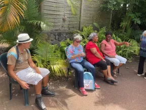 Groupe de personnes assises dans un jardin de palmier et de fougéres