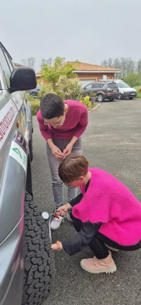 Le 09 avril 2025 Laure et Harmonie contrôlent la pression du pneu avant du 4x4 Iris