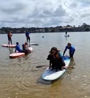 Sur le paddle Anne-Marie a genoux rassurant Ruby son chien-guide