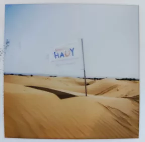 Le drapeau de l'association flotte au dessus d'une dune dans le désert marocain.
