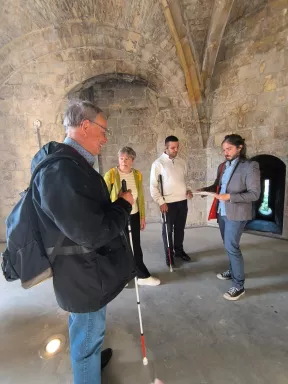 Sous les voûtes du château, les participants de la visite, attentifs aux propos de Simon Lanry, médiateur culturel