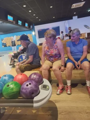 Les bénéficiaires entourent le présentoir des boules de bowling