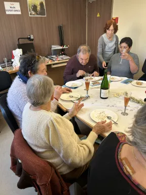 Photo des bénéficiaires autour de la table du repas de noël