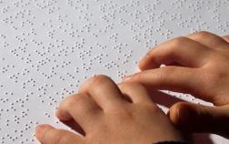 image de main sur une feuille avec du braille écrit