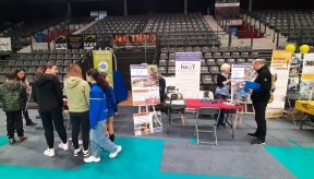 Stand de l'AVH dans une vaste salle de sport, avec des gradins au fond