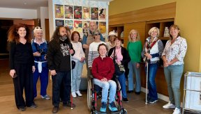 Plusieurs personnes dont une en fauteuil roulant dans le hall d'accueil d'un musée