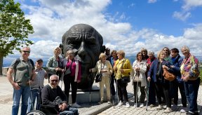 Plusieurs personnes prennent la pose autour d'une statue de plus de 2 mètres de haut représentant la tête de Picasso 