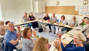Plusieurs personnes autour de tables disposées en carré