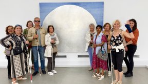 Deux groupes de visiteurs prennent la pose photo autour d'une œuvre d'art