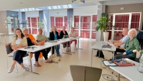 Des personnes autour de deux tables pendant une réunion de travail