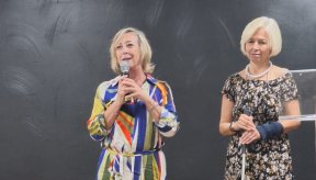 Deux dames debout. Celle de gauche tient un micro.