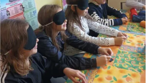 Quatre enfants portent un masque noir et touchent des objets