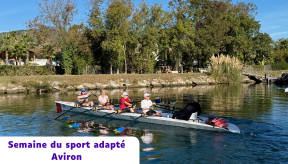 ne équipe de quatre rameurs seniors et un barreur pratiquent l'aviron sur une rivière calme et ensoleillée. Les sportifs sont à bord d'une fine embarcation blanche, synchronisant leurs mouvements de rames sur l'eau bleue. En arrière-plan, la berge est bordée d'arbres verdoyants, de quelques palmiers et de maisons. Un encadré en bas à gauche contient l'inscription : « Semaine du sport adapté - Aviron ».