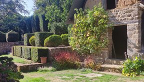 Vue sur une partie du manoir de la Boisnerie : jardin et mur en pierre